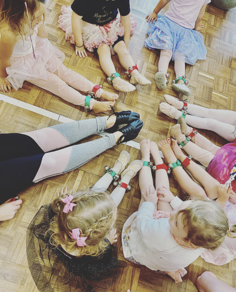 Care home residents and toddlers dancing together with props