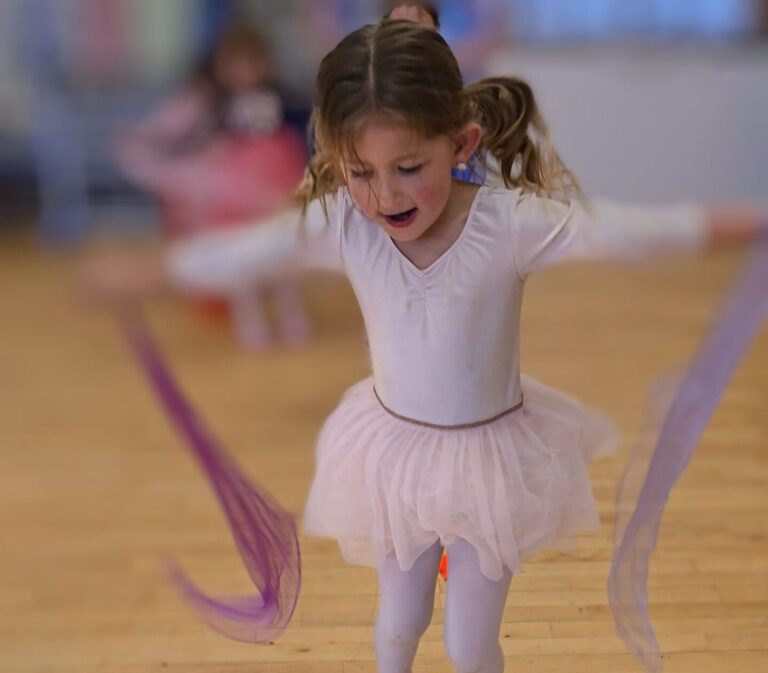 A young ballerina twirls with lilac scarves at Magical Tots – Dance Classes for Two Year Olds Near Me.